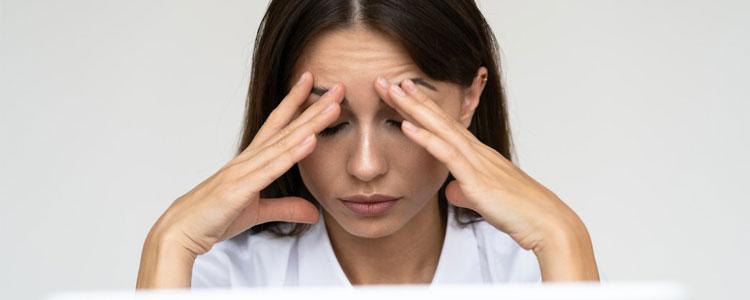 Woman rubbing her forehead because of a headache or migraine