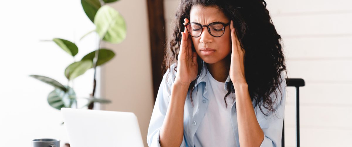 Exhausted young african-american businesswoman having headache in office. Bored young african girl tired of learning sit at home looking at laptop, lazy apathetic black female university student frustrated about study computer work feeling uninterested demotivated